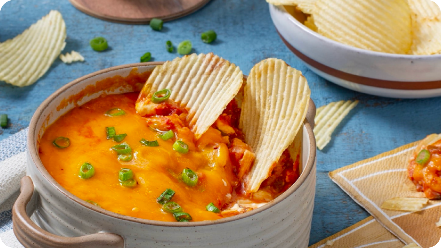 Ruffles in a bowl of cheese dip