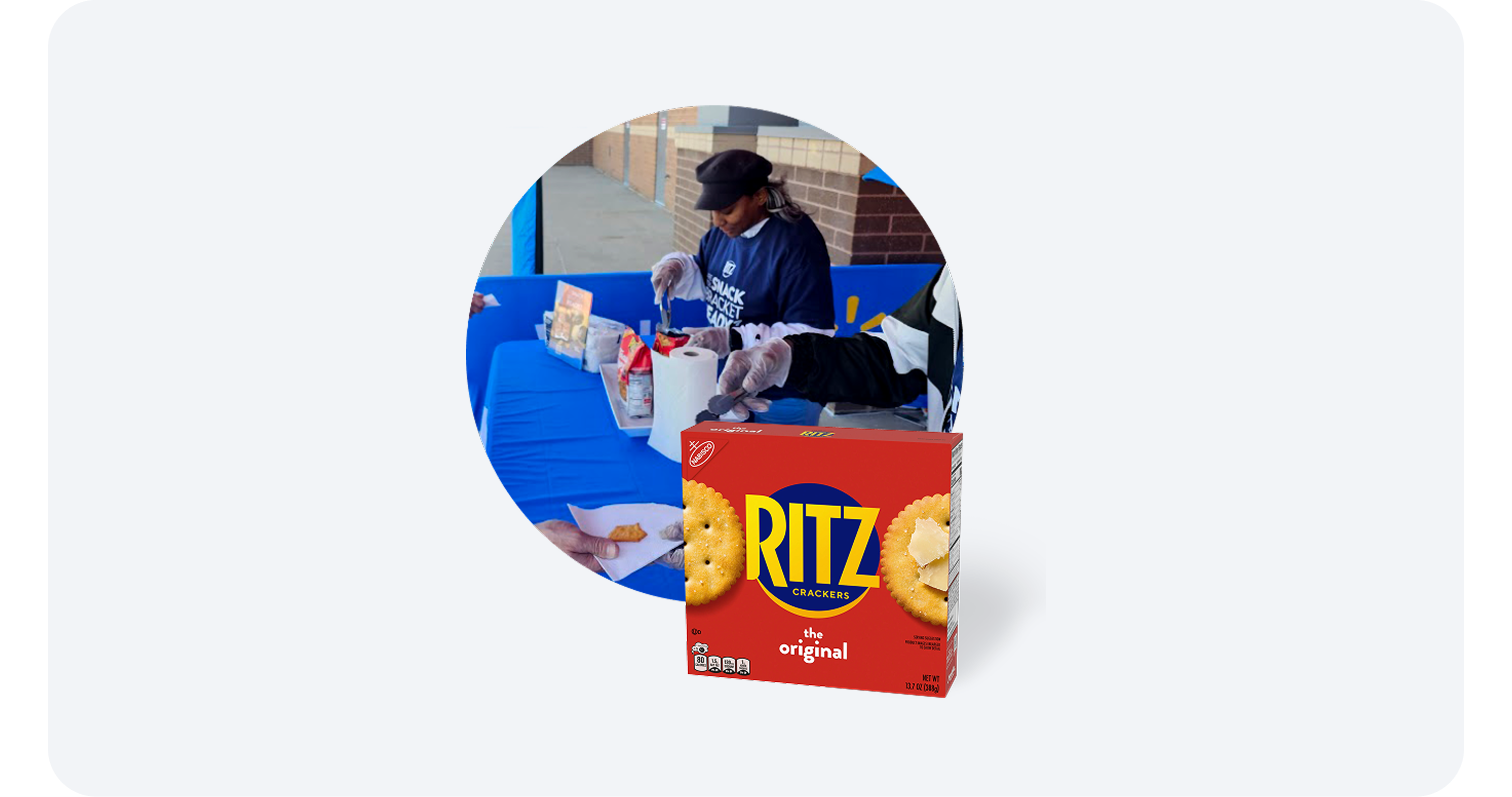 Store associate handing out Ritz cracker samples at a demo table with a Ritz box in front.
