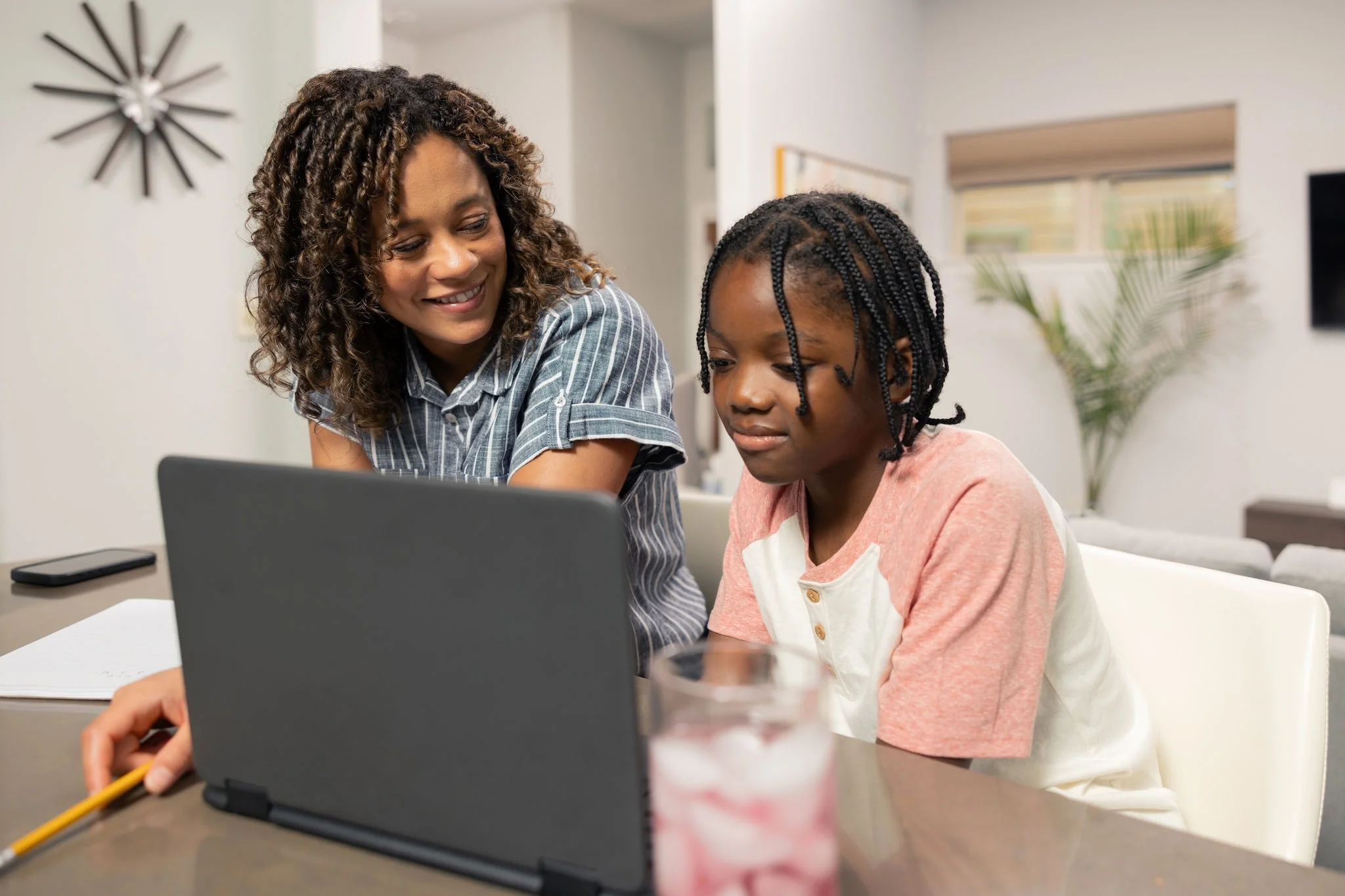 Mother and daughter working on a laptop at home.