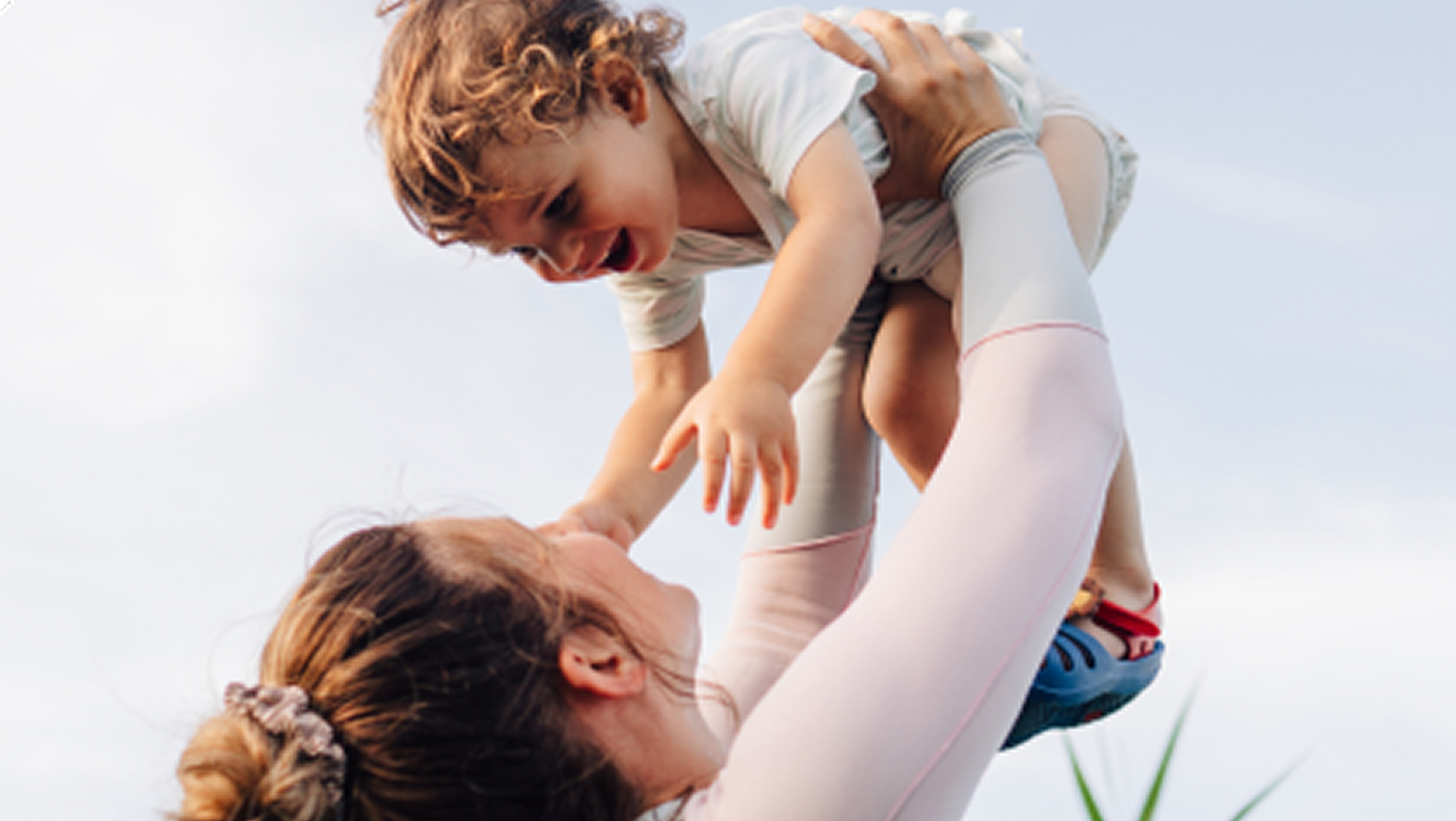 woman lifting her baby over her head