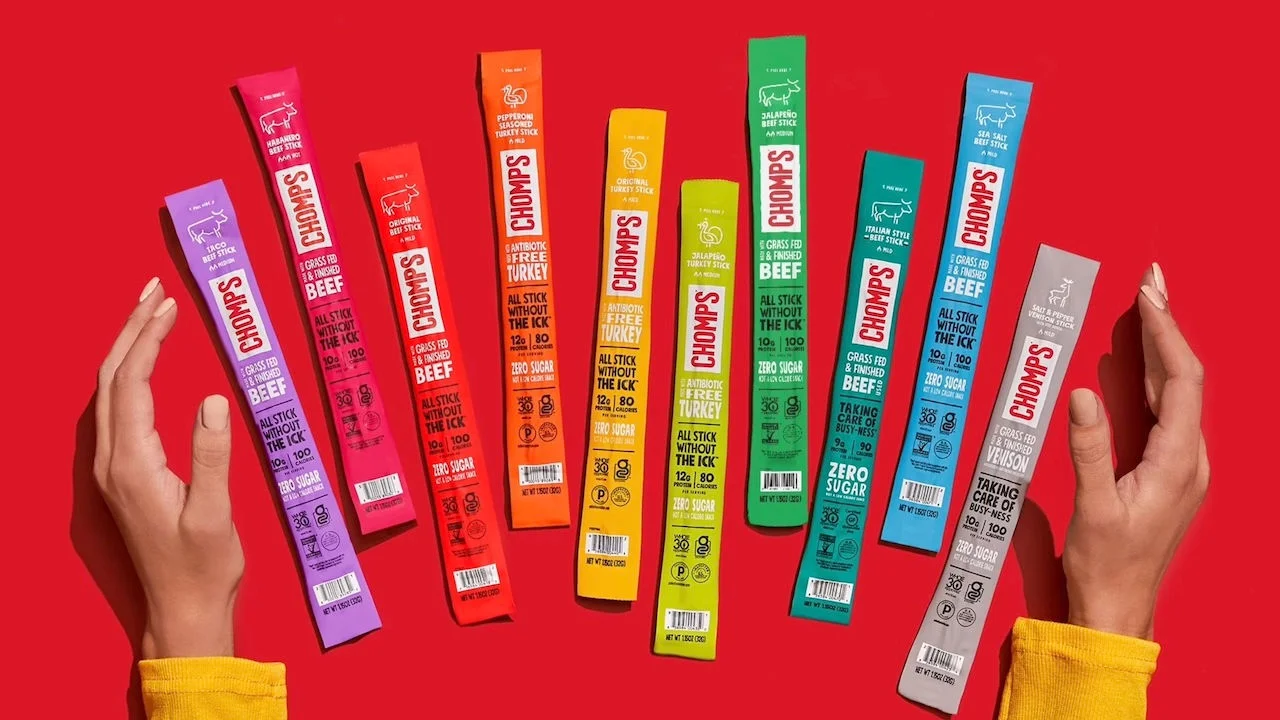 A selection of Chomps products laid out on a red background.