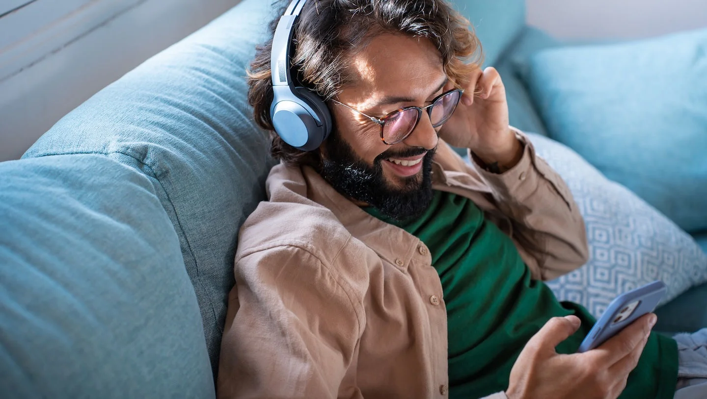 man wearing headphone with mobile phone