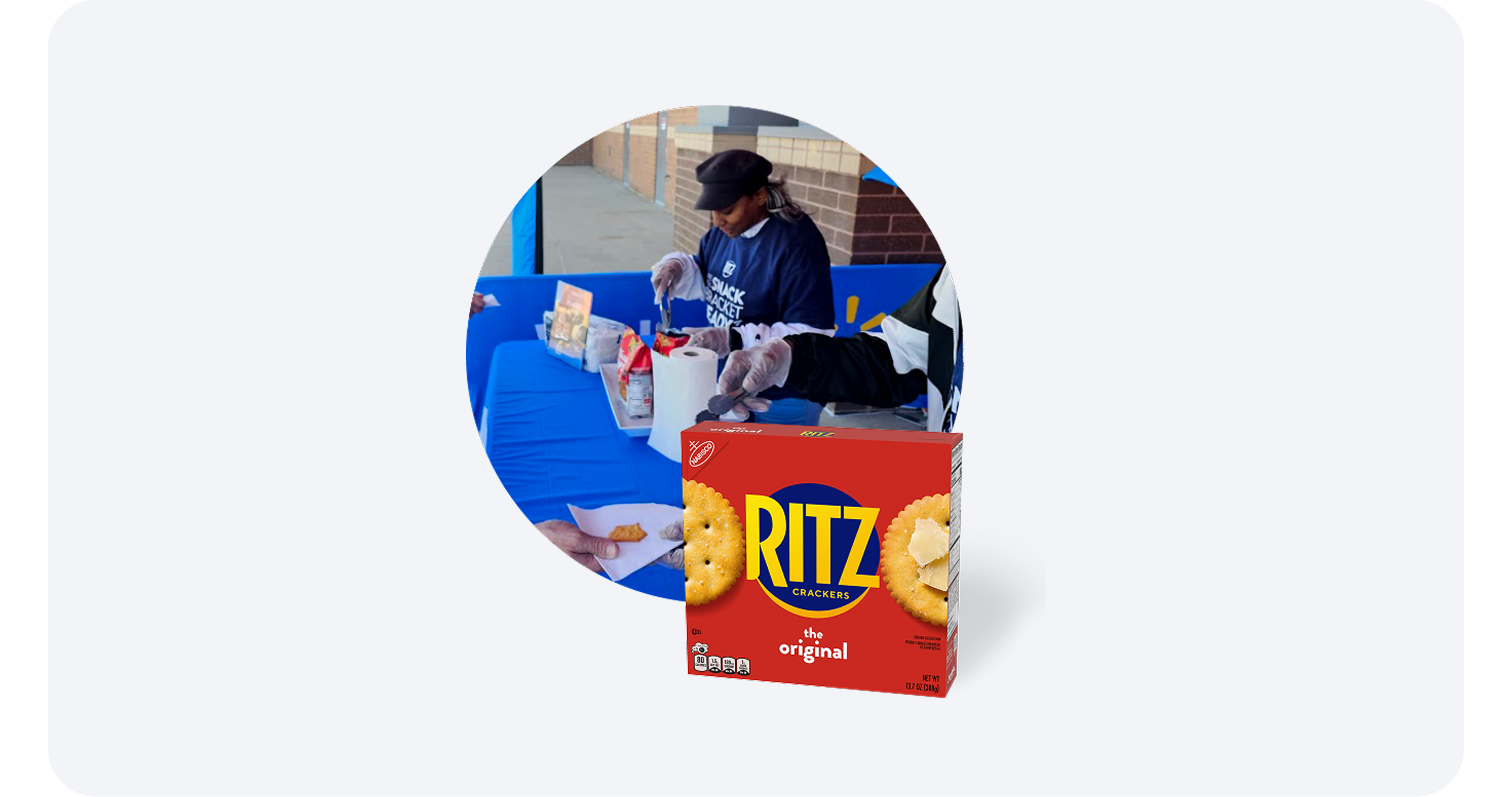 Store associate handing out Ritz cracker samples at a demo table with a Ritz box in front.